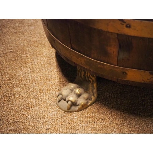 173 - A stunning antique coopered brass bound log box on lion paw feet.