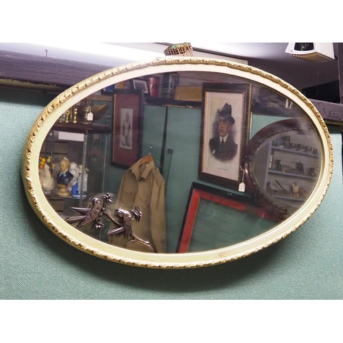 318 - An antique oval framed mirror.