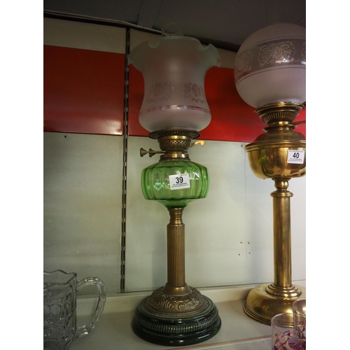 39 - An antique oil lamp with brass base, green glass font & etched shade.