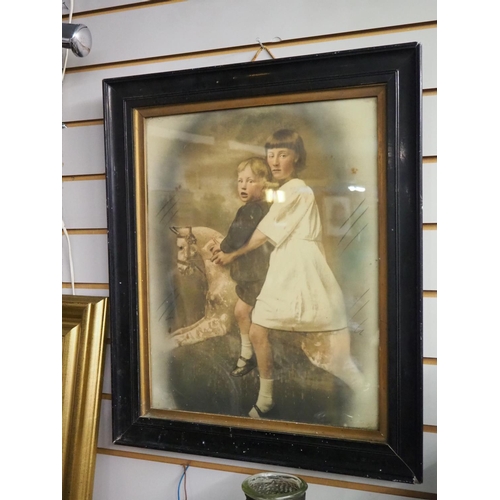 384 - A framed vintage print of children on rocking horse.