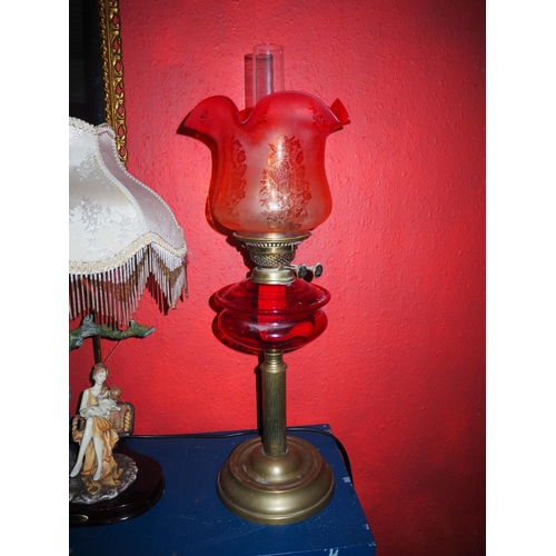 575 - An antique oil lamp with red glass font & etched glass shade.