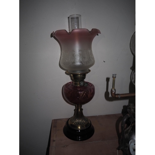 576 - An antique oil lamp with red glass font & etched glass shade.