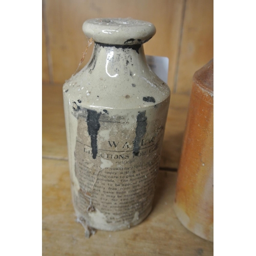 763 - A pair of stoneware bottles. One with part label