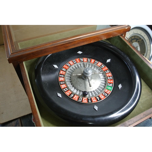 541 - A vintage cased roulette wheel to include chips and tokens.