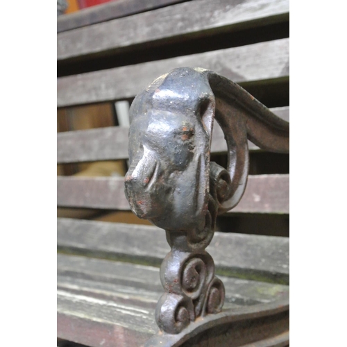 235 - A garden bench with cast iron lion mask ends, in need of restoration.