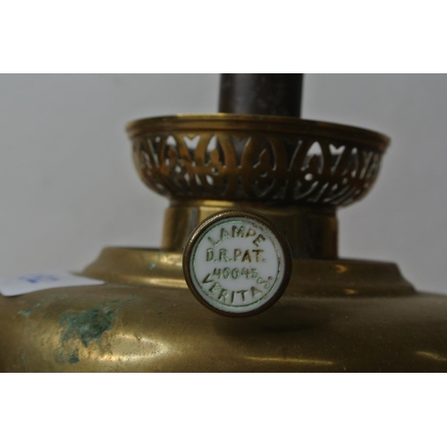 132 - A brass font for an oil lamp, a clear glass oil lamp base and an oil lamp burner