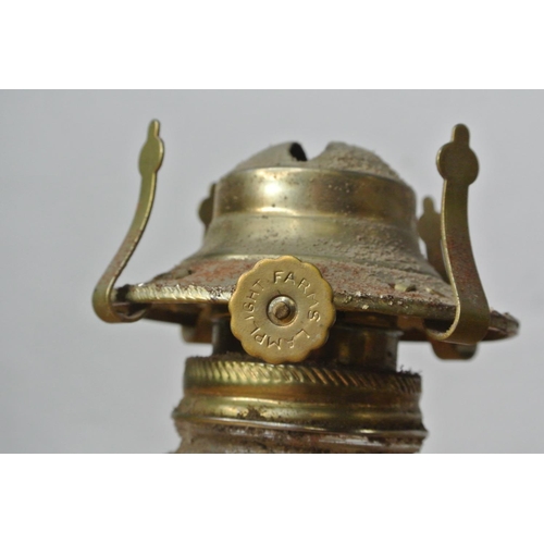 132 - A brass font for an oil lamp, a clear glass oil lamp base and an oil lamp burner