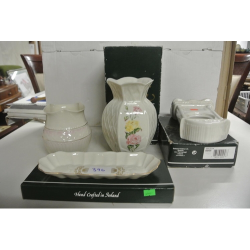 396 - A collection of Belleek pieces to include two vases, a model of a clock and a dish