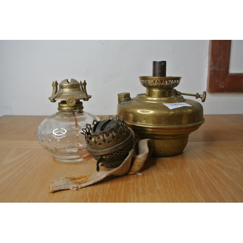 132 - A brass font for an oil lamp, a clear glass oil lamp base and an oil lamp burner