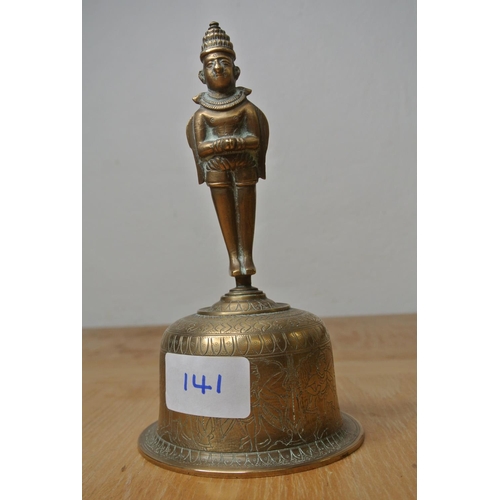 141 - An Indian brass bell with engravings