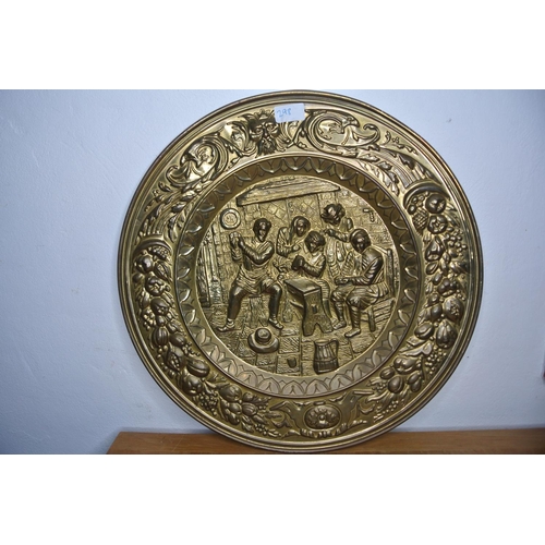 298 - A large heavily detailed brass charger depicting a old tavern scene