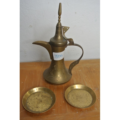 300 - A brass Al-Jaber coffee pot from Dubai along with two small brass dishes