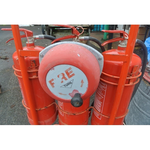 497 - A vintage triple fire extinguisher stand with built-in fire bell, along with three fire extinguisher... 