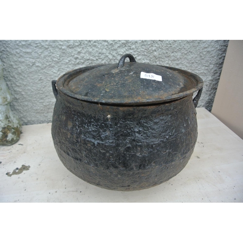 518 - A large cast iron cooking pot with original lid.