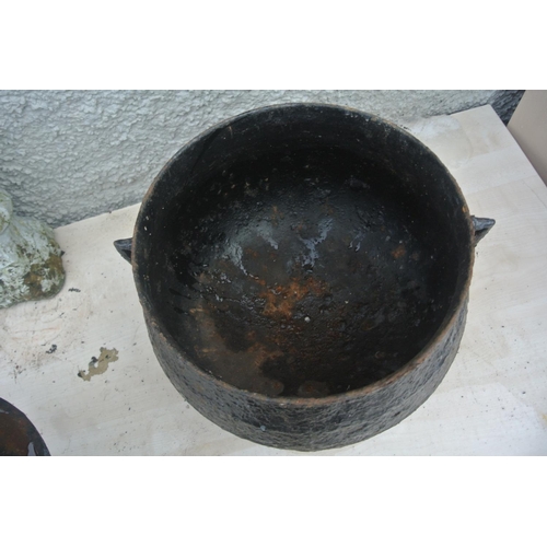 518 - A large cast iron cooking pot with original lid.