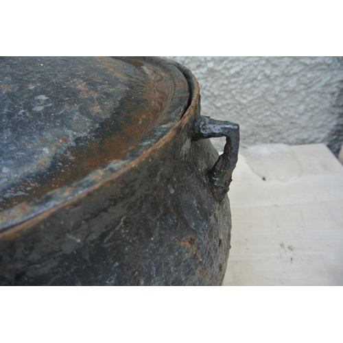 518 - A large cast iron cooking pot with original lid.