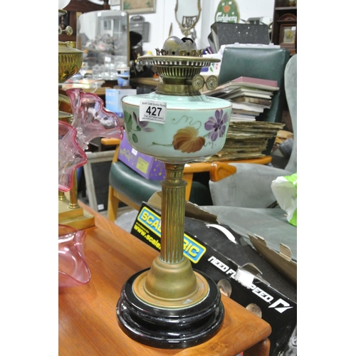 427 - An antique oil lamp base on brass pillar with painted glass reservoir.