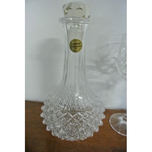 83 - A collection of crystal glasses along with a French decanter.