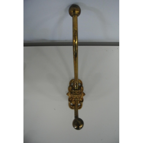 168 - A collection of nine vintage brass coat hangers.