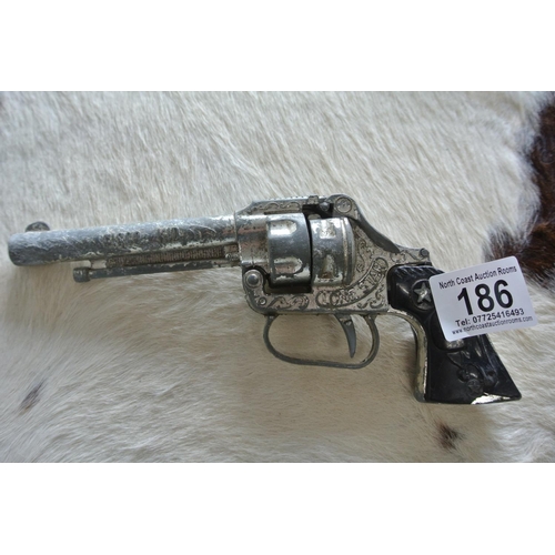 186 - A vintage Lone Star revolver along with a vintage toy badge reading, 'Sheriff - City of Tombstone.