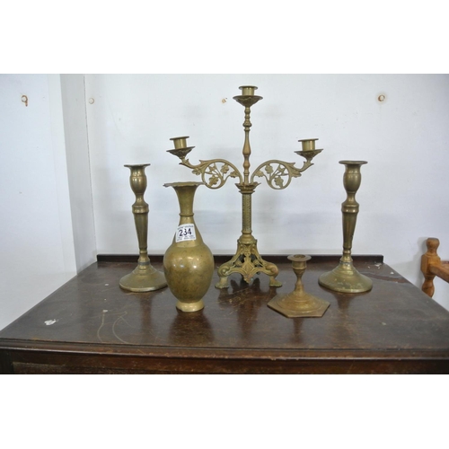 234 - An assortment of brass items to include a stunning three tier candelabra, three other candle sticks ... 