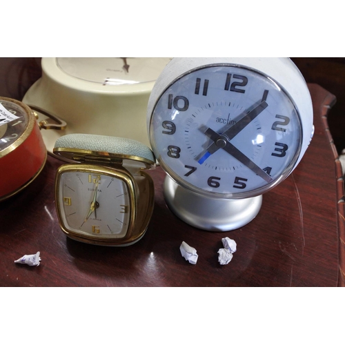 442 - An assortment of clocks to include two alarm clocks, a travel clock and a wall clock.