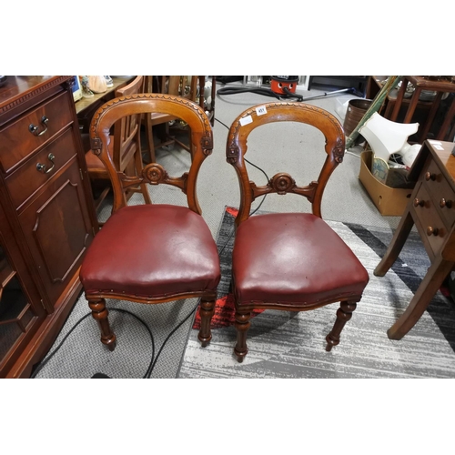 451 - A stunning pair of antique chairs with decorative splats and red leather upholster.