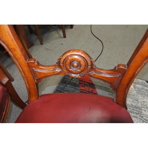 451 - A stunning pair of antique chairs with decorative splats and red leather upholster.