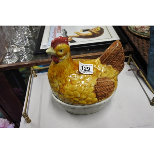 129 - A ceramic egg holder in the shape of a hen.