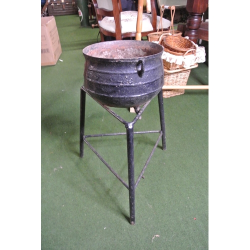 257 - A cast iron cooking pot (a/f) and stand.