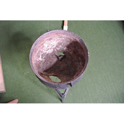 257 - A cast iron cooking pot (a/f) and stand.