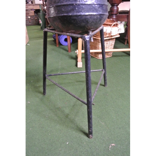 257 - A cast iron cooking pot (a/f) and stand.