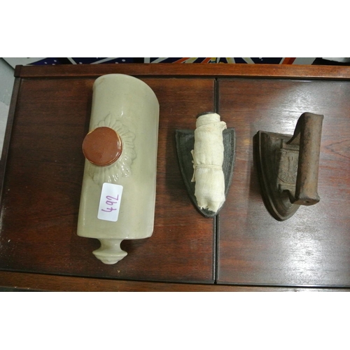 492 - A stone ware hot water bottle along with two cast iron irons.