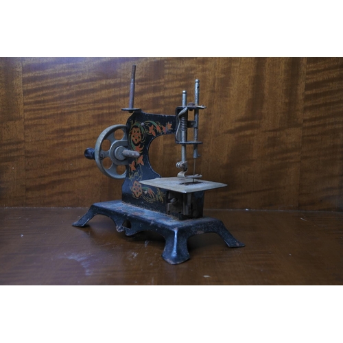 132 - A small tin plate model sewing machine.