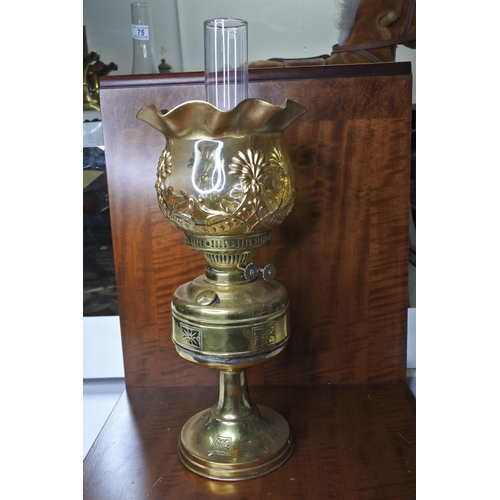 138 - A decorative brass oil lamp with painted flower globe