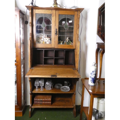 161 - An antique/Art Nouveau oak bookcase bureau, with leaded glass doors.
