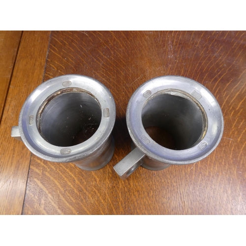 51 - A pair of heavy vintage pewter tankards with dragon designs, each lacking glass bases.