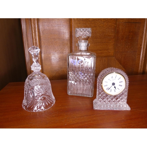 597 - An assortment of crystal to include bell, clock & cut glass decanter.