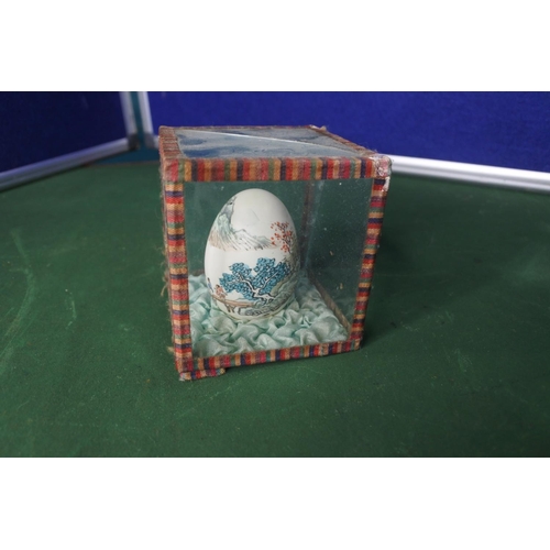 653 - A hand painted Chinese/ Oriental egg in glass case.