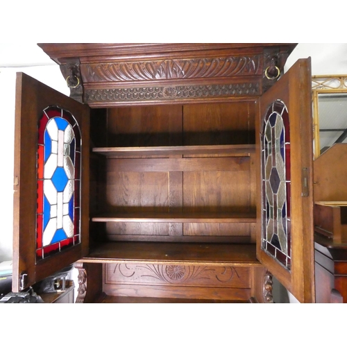 678 - A stunning antique Gothic style cabinet with heavily carved detail & stained glass doors.