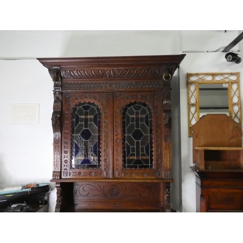 678 - A stunning antique Gothic style cabinet with heavily carved detail & stained glass doors.