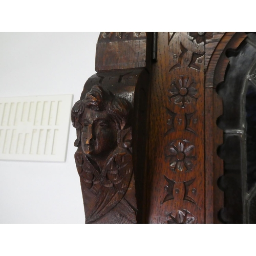 678 - A stunning antique Gothic style cabinet with heavily carved detail & stained glass doors.