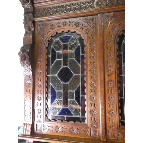 678 - A stunning antique Gothic style cabinet with heavily carved detail & stained glass doors.