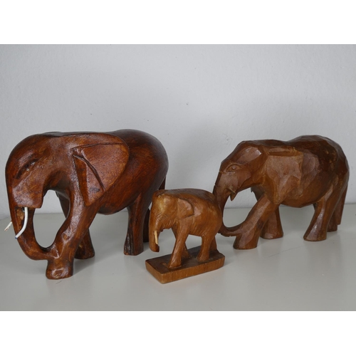 116 - A collection of 3 hand carved wooden elephants.