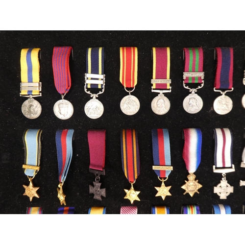 34 - A framed display of 60 miniature medals.