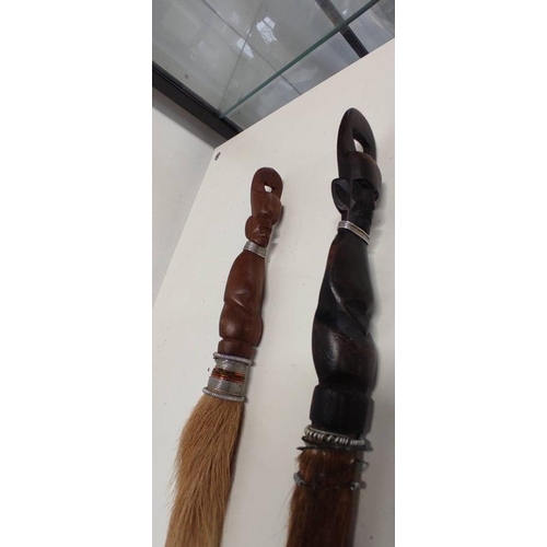 71 - A pair of horsehair tribal brushes with carved handles.