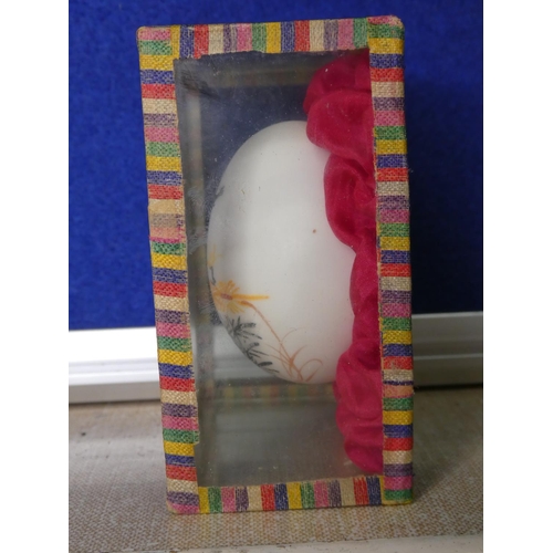 82 - A cased hand painted egg.