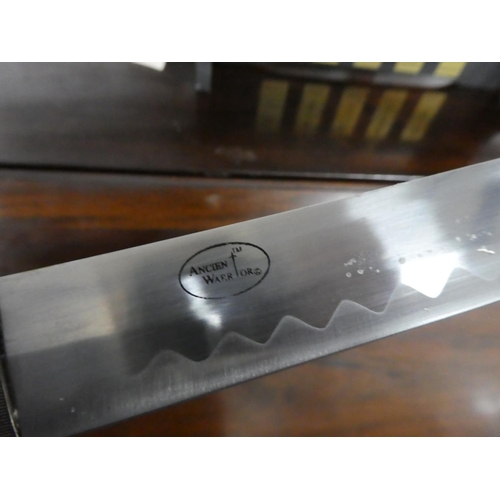 106 - A set of five martial art samurai swords on presentation stand.