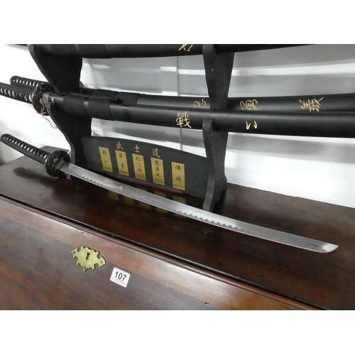 106 - A set of five martial art samurai swords on presentation stand.