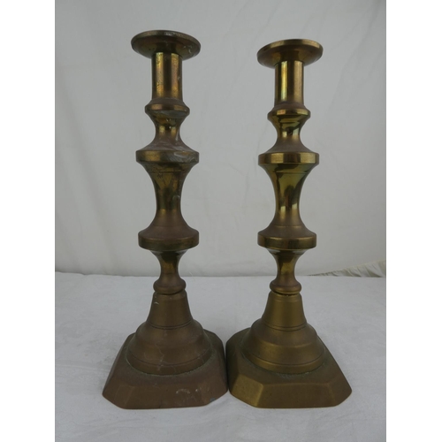 79 - A pair of antique brass candlesticks.